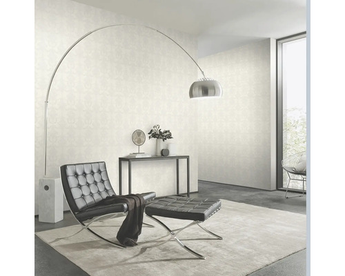 Vardagsrum med tapet, fåtölj, pall och golvlampa.