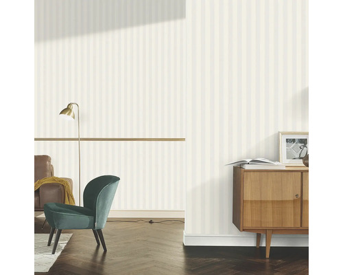 Vardagsrum med randig tapet, fåtölj och byrå