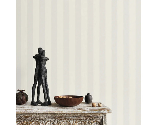 Fotografi av en dekoration på ett bord med randig tapet i bakgrunden.