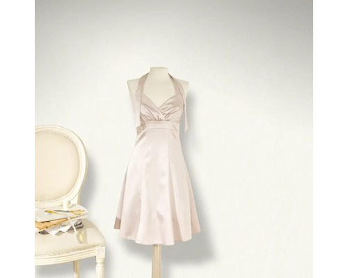 Klänning på skyltdocka bredvid stol med sytillbehör