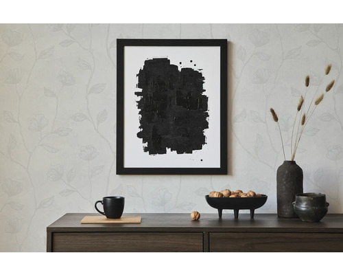 Dekorativt stilleben med inramad abstrakt bild, servis och torkade blommor på en byrå.