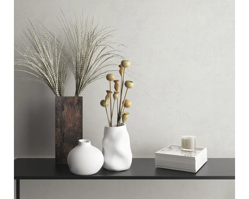 Dekorativt stilleben med vaser, prydnadsgräs, dekorativa grenar och ljus på en konsol