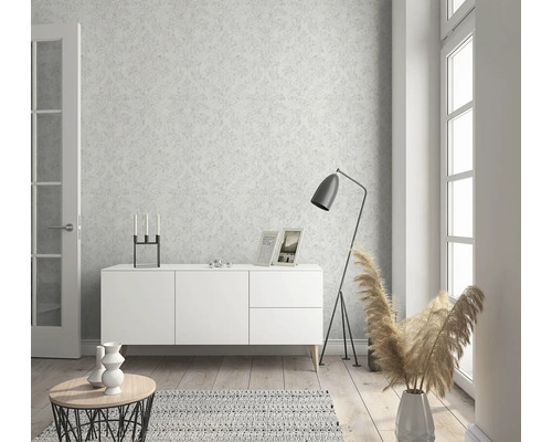 Ljust vardagsrum med mönstrad tapet, skänk, golvlampa och dekoration