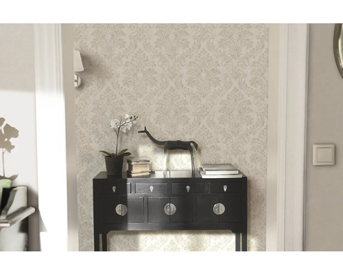 Elegant rum med mönstrad tapet, byrå och dekoration