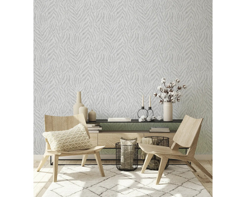 Vardagsrum med mönstrad tapet, matta och trämöbler.