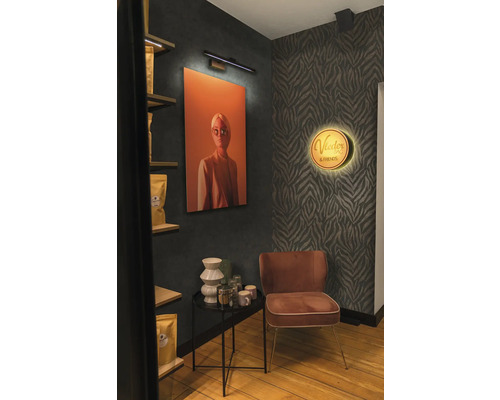 Dekorativ interiör med målning, lampa, hylla, sidobord och stol