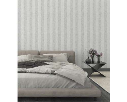 Sovrum med säng, sängbord och randig tapet