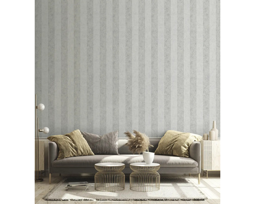 Vardagsrum med randig tapet, soffa, sidobord och dekorativa element för en stilfull atmosfär.