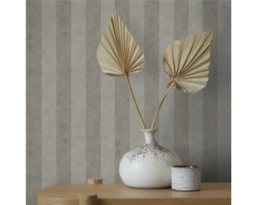 Dekorativ tapet med randigt mönster och bordsdekoration med torkade blommor i vas