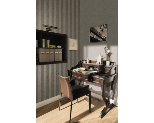 Interiörvy av ett arbetsrum med skrivbord, stol, hylla och väggdekoration