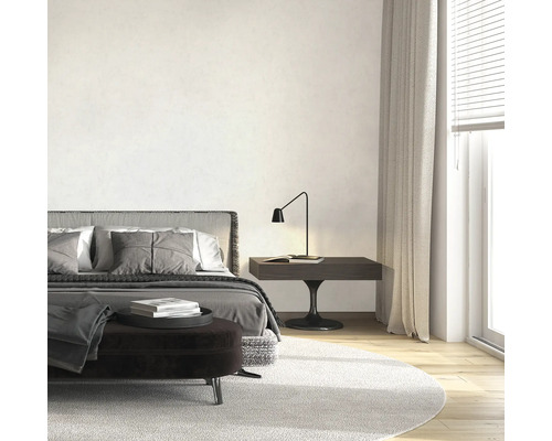 Ljust sovrum med säng, sängbord och matta