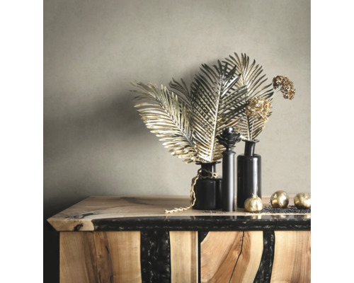 Dekorativa gyllene blad och bollar i svarta vaser på en byrå av trä och epoxiharts.