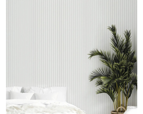 Ljust sovrum med säng, krukväxt och vertikala väggpaneler