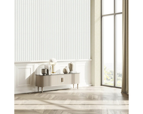 Ljust vardagsrum med räfflad tapet, skänk, lampa och stort fönster