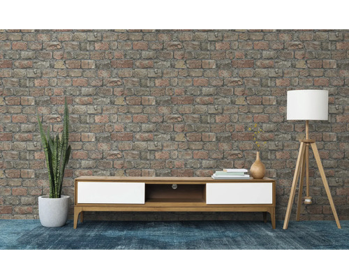 Vardagsrum med låg skänk, golvlampa och tegelvägg