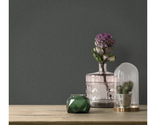 Dekorativa tillbehör på ett bord framför en mörk tapet