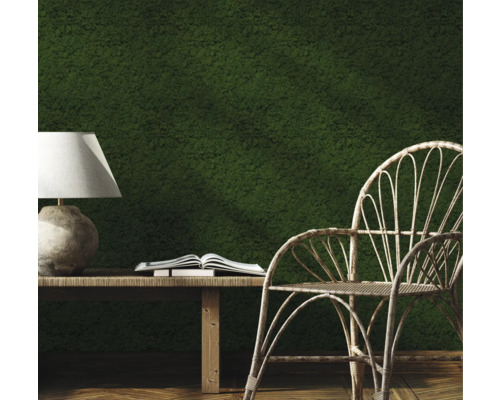 Dekorativ inredning med mossvägg, bord, lampa, bok och stol