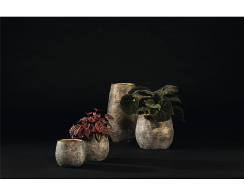 Arrangemang av tre strukturerade blomkrukor med växter