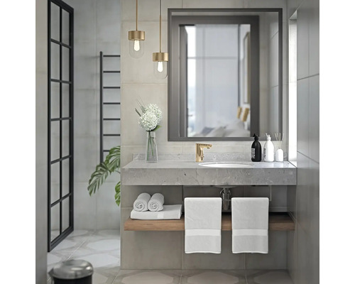 Modernt badrum med handfat, spegel, handdukar och belysning