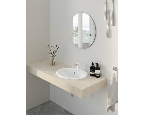 Ljust badrum med tvättställ, tvättskål, spegel och handdukshållare.