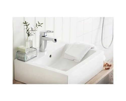 Modern tvättställ i badrum med blandare, handduk och dekoration