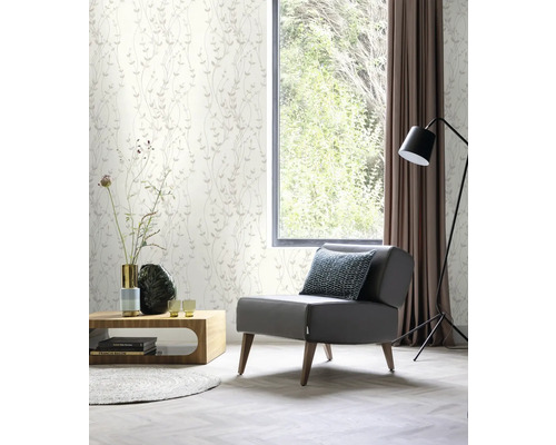 Vardagsrum med blommig tapet, fåtölj och fönster