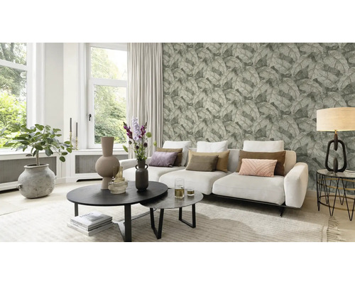 Vardagsrum med soffa, soffbord och tapet med bladmönster