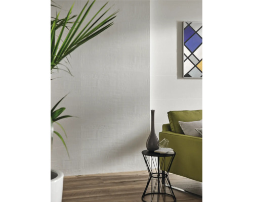 Vardagsrum med vita väggplattor i träutseende, grön växt, soffa och sidobord