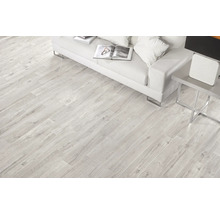 Ljust vardagsrum med golvplattor i träimitation, soffa och sidobord