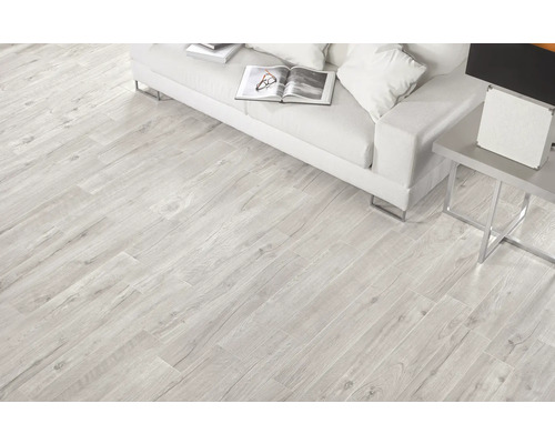 Ljust vardagsrum med golvplattor i träimitation, soffa och sidobord