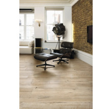 Vardagsrum med trägolv, fåtölj och golvlampa