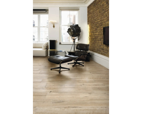 Vardagsrum med trägolv, fåtölj och golvlampa