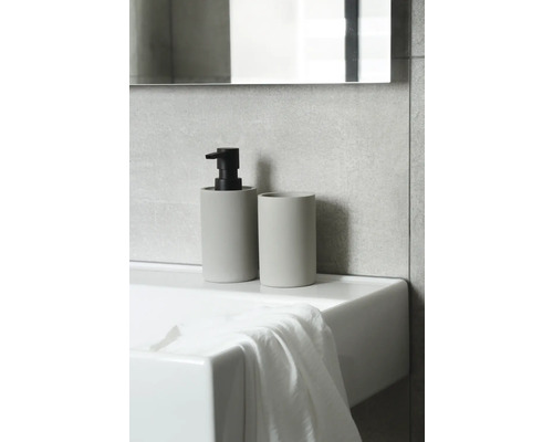 Tvålpump och tandborstmugg i keramik på ett handfat