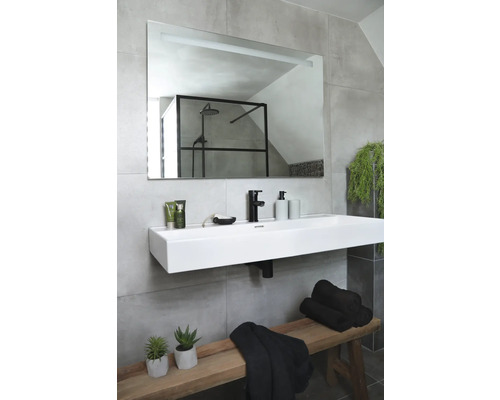 Badrum med handfat, spegel, handdukar och dekoration på en träbänk.