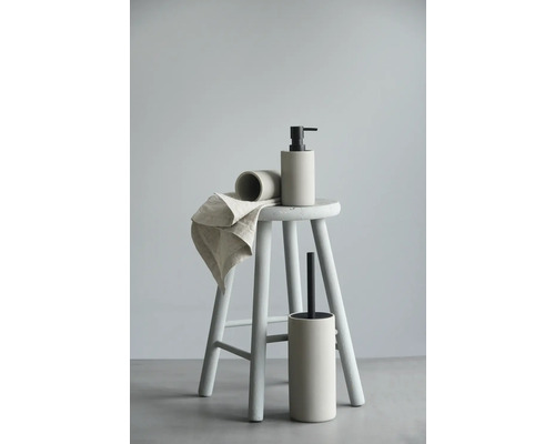 Badrumsset med tvålpump, mugg och toalettborste på en pall