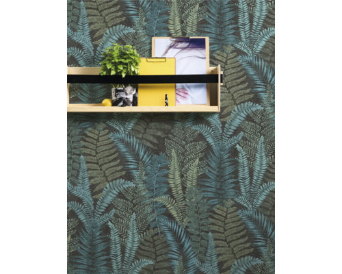 Vägg med tapet med ormbunksmönster och trähylla med dekoration