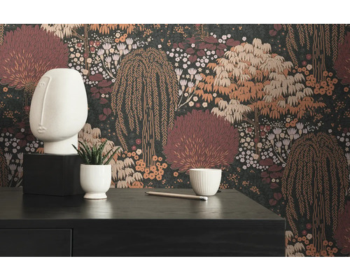 Dekorativt rum med mörk tapet med blommönster, en vit skulptur, en liten växt och ett skrivbord