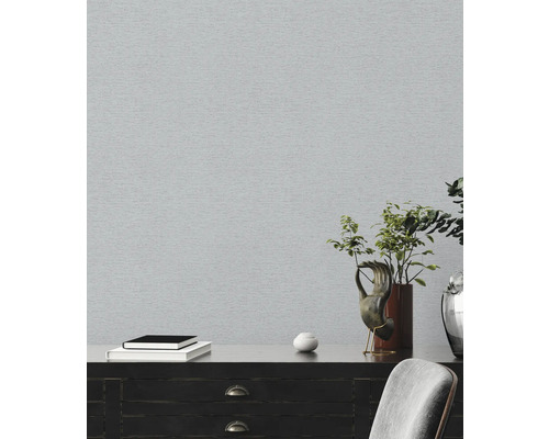 Ljust rum med grå tapet och mörk byrå med dekoration