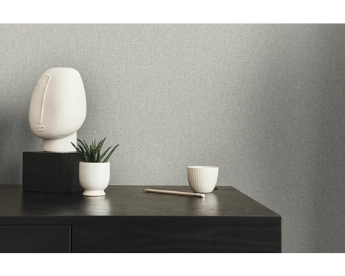 Närbild av en grå non-woven tapet med minimalistisk dekoration på ett bord
