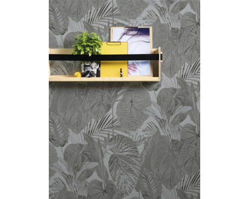 Fotografi av en vägg med blad tapet och en vägghylla med dekoration