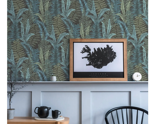 Dekorativ vägg med tapet med ormbunksmönster, en inramad Island-affisch och dekorativa föremål