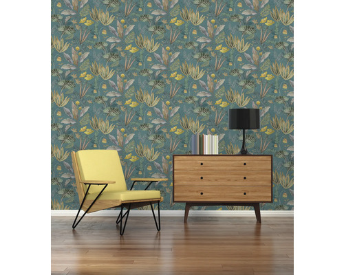 Vardagsrum med mönstrad tapet, fåtölj och byrå