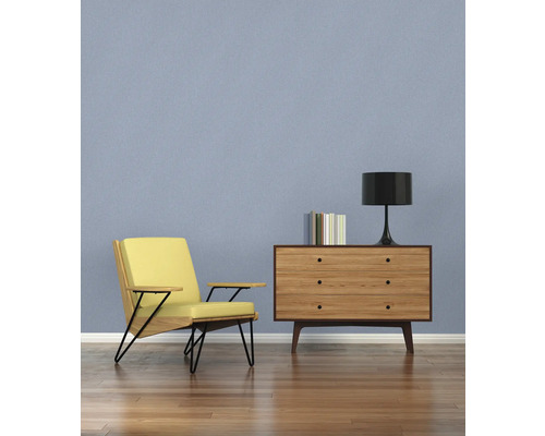 Vardagsrum med fåtölj, byrå och lampa