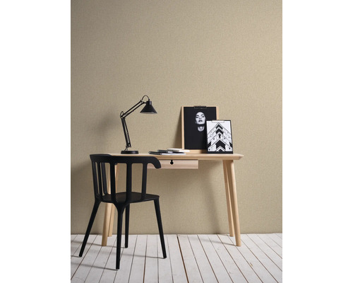 Arbetsrum med skrivbord, stol och lampa framför en strukturerad tapet