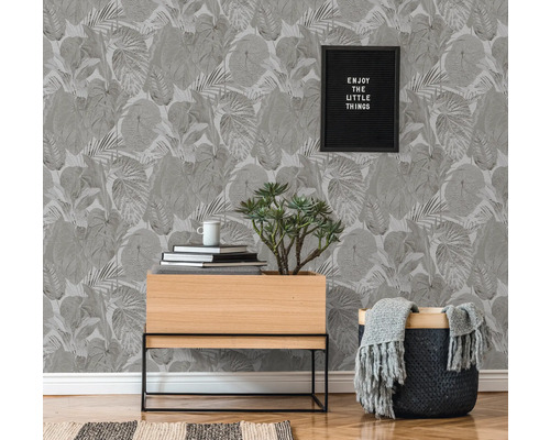 Vardagsrum med botanisk mönstrad tapet, växtbord och dekorationer för en naturlig atmosfär