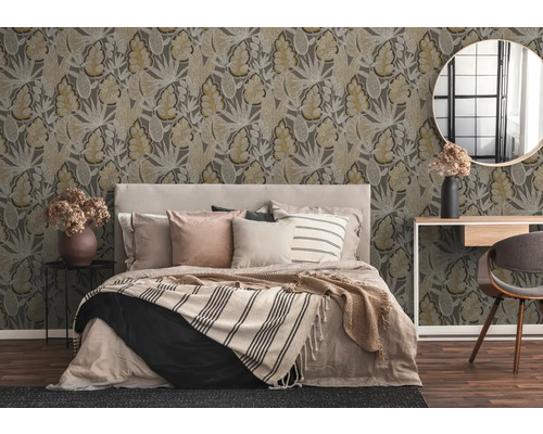 Sovrum med mönstrad tapet, säng, bord, stol och spegel