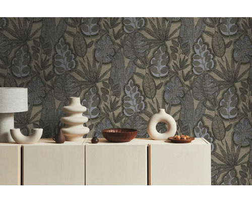 Interiör med mönstrad tapet och dekorativa föremål på en byrå