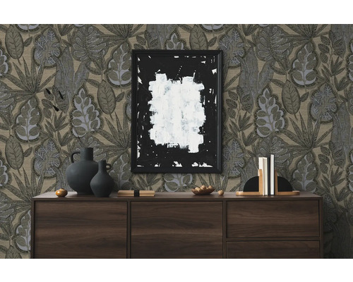 Vardagsrumsscen med byrå, dekorativa föremål, en inramad bild och tapeter med bladmönster