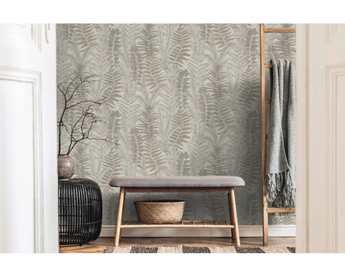 Dekorativ interiör med tapet med ormbunksmönster, bänk och stege med filt