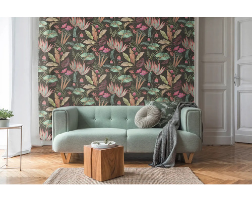 Vardagsrum med mönstrad tapet, soffa och trägolv